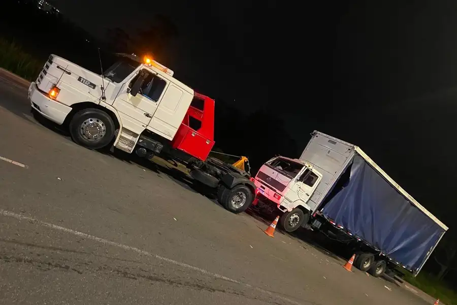 Equipe e guincho posicionados em operação noturna com cones de sinalização